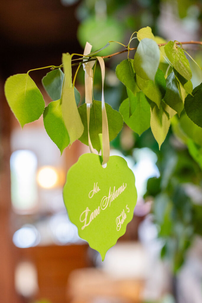 Guest table assignments shaped like leaves hang from a tree. 